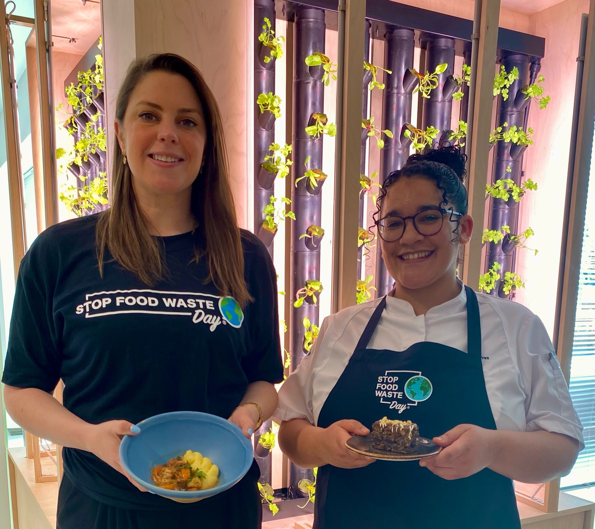 Ashleigh Taylor, Head of Environment and Aisha Joel with her SFWD Spiced Carrot and Coffee Grounds cake